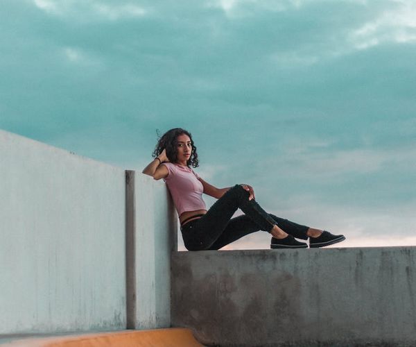 Person doing a balancing yoga pose against a clear sky background.